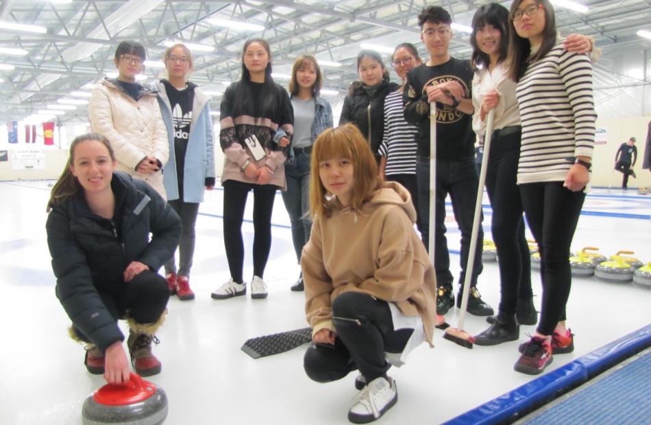 New Zealand under-19 curling team member Jessica Smith (19, front left), of Naseby, shows members of a visiting group from the Shanghai Institute of Technology the finer points of curling after the group's session at the Naseby Indoor Curling Rink on Satu