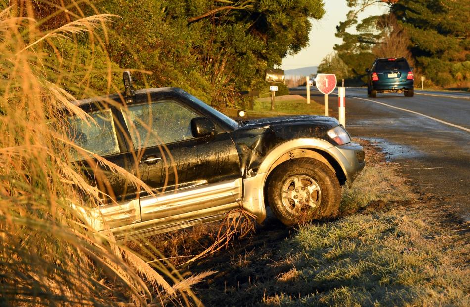 A SUV in a ditch beside slippery State Highway 1 in East Taieri yesterday. Photos: Stephen Jaquiery.