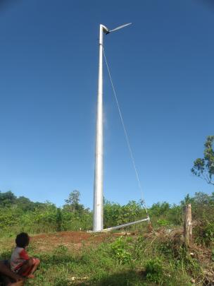 A child watches the new Thinair wind turbine installed at the Bishop Koete Rural Training Centre in the Solomon Islands.