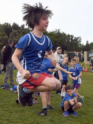 Quinn Byers (11), of Macandrew Bay School, shows some energy in his warm-up before the years 5...