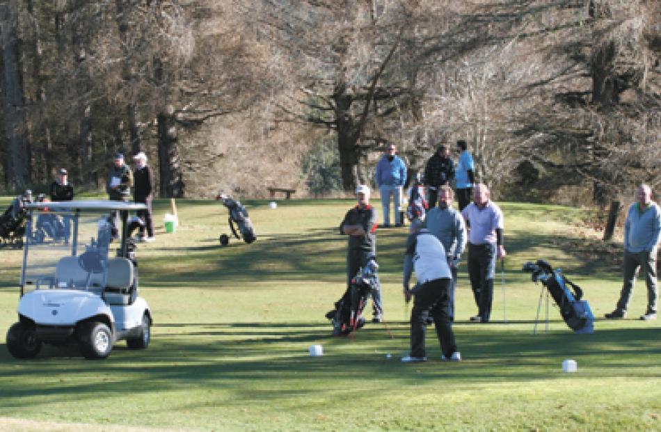 Golfers gathered at the 17th hole. 
