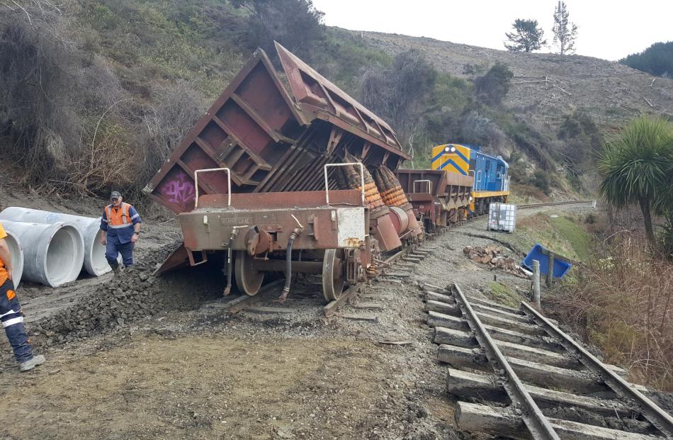 A wagon dumps fill for repairs on the railway line.