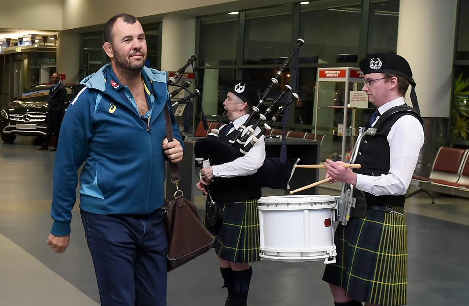 Wallabies coach Michael Cheika strolls past members of the City of Dunedin Pipe Band.