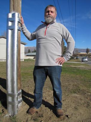 Former Delta Utilities Services employee Richard Healey inspects a pole that has been ``nailed''...