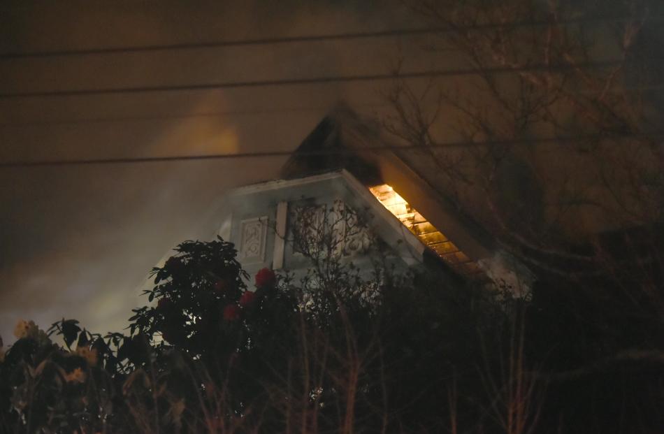 Flames lick at the eaves of a Tweed St house in Dunedin. Photos: Gregor Richardson.
