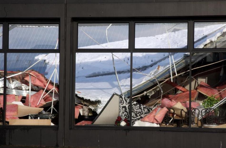 Looking inside the window of Wrens store after heavy snowfall caused the roof to collapse. Credit...