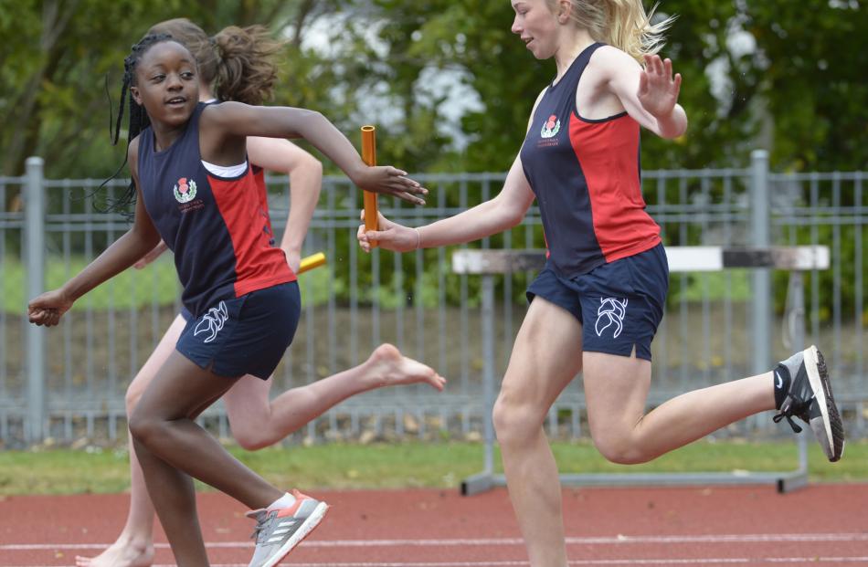 Samantha Grey (right, 12) passes the baton to Elizabeth Olusina (12) for Balmacewen Intermediate...