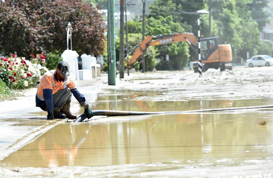 Russell Davies, of Alexandra, clears a drain in Scotland St, Roxburgh's main street.
