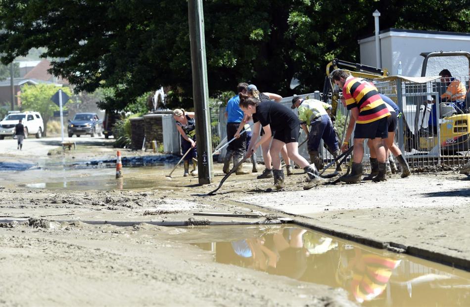 Volunteers clean up the mud outside Roxburgh Area School.