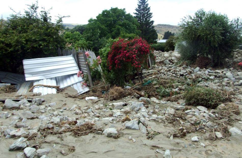 A damaged garden in Tweed St, near Reservoir Creek yesterday afternoon. The garden shed was thrown over the other side of the back lawn and the surrounding fence was destroyed.