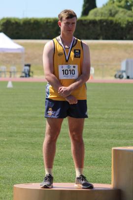 Hamish Mears (16) accepts the senior boys shotput bronze medal.