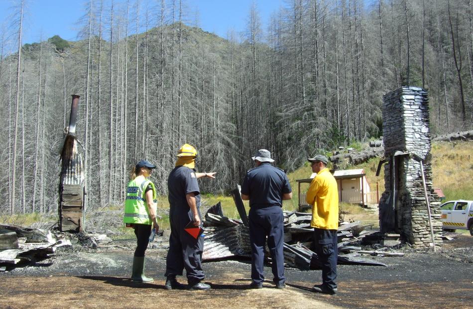 Detectives and Fire and Emergency New Zealand officers examine the remains of Mount Aurum...