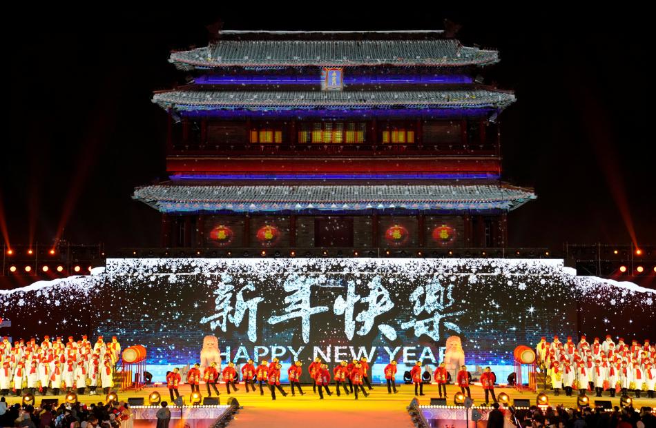 People dance to celebrate the new year during a countdown event at Yongdingmen Gate in Beijing....