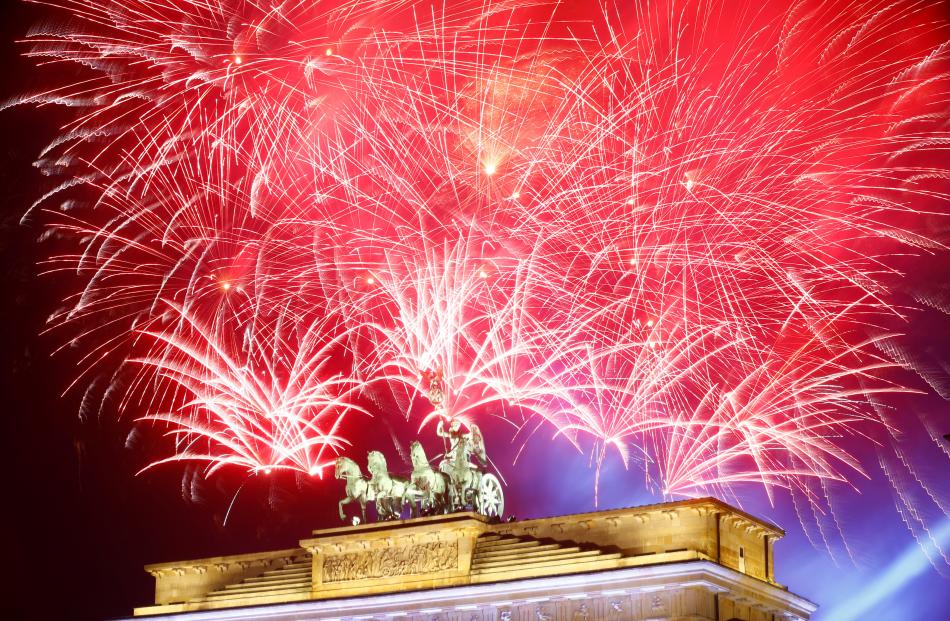 Fireworks explode next to the Quadriga sculpture atop the Brandenburg gate during New Year...