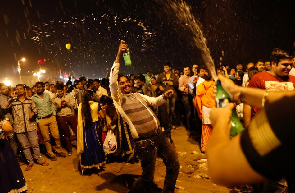 People dance during the New Year's celebrations on a beach in Mumbai, India. Photo: Reuters