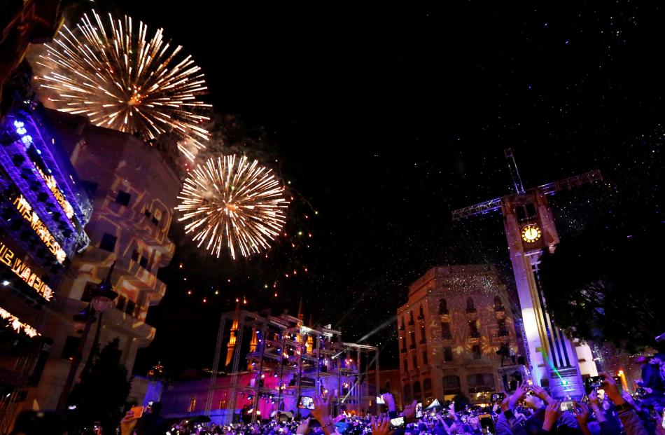 People watch fireworks in the rain on New Year's Day in downtown Beirut, Lebanon. Photo: Reuters