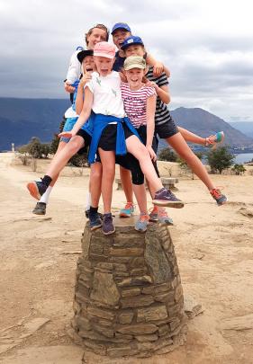 Six cousins balanced on the stone cairn at the top of Mt Iron in  Wanaka on January 10  are (from...