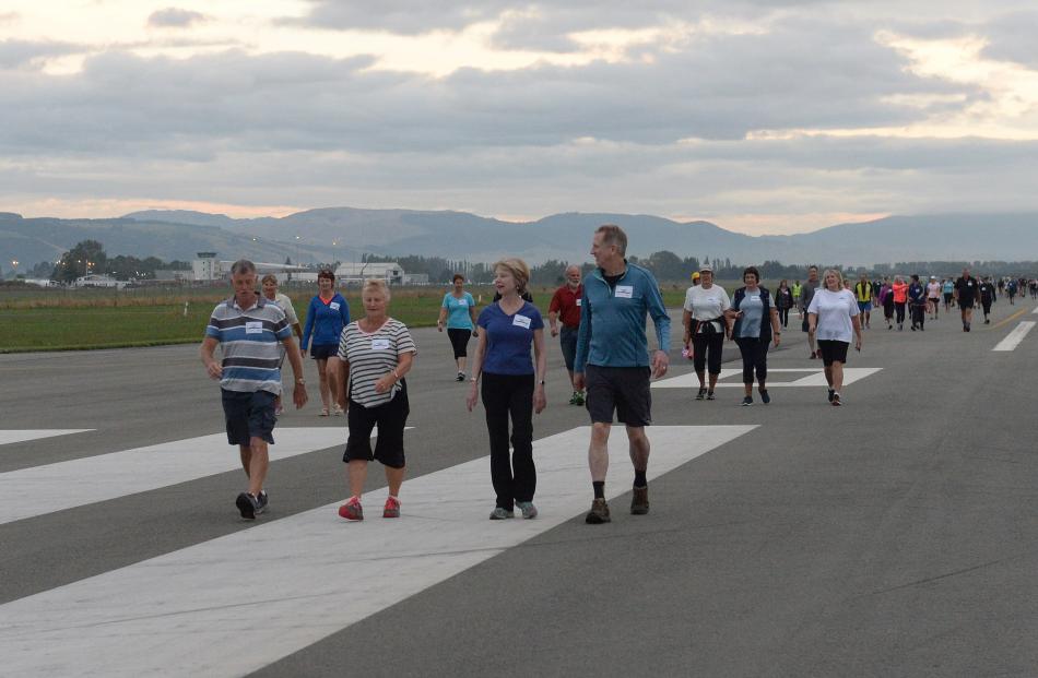 Walkers continue down the runway.