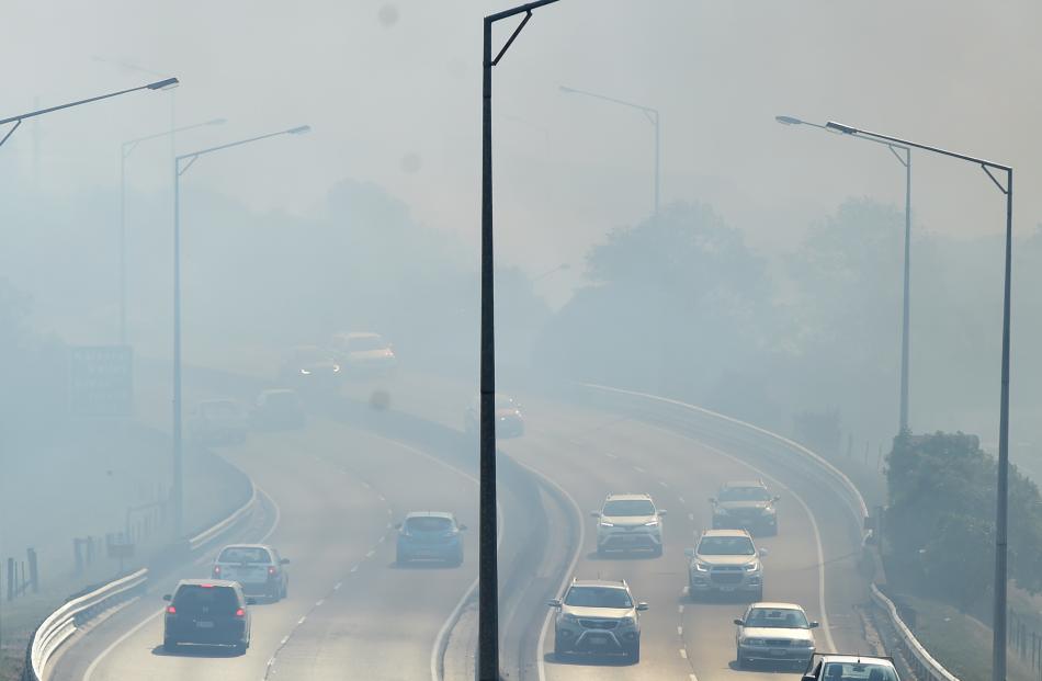 Smoke drifts across the Southern Motorway shortly before it was closed for the night.
