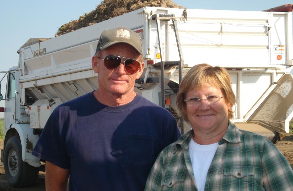 John and Meredith McLeod cover up during their potato harvest due to the sun and heat. The temperature tops 30degC every day in summer and sometimes hits 40degC. The leaf material among the potatoes on the truck behind them has to be removed by hand. Phot