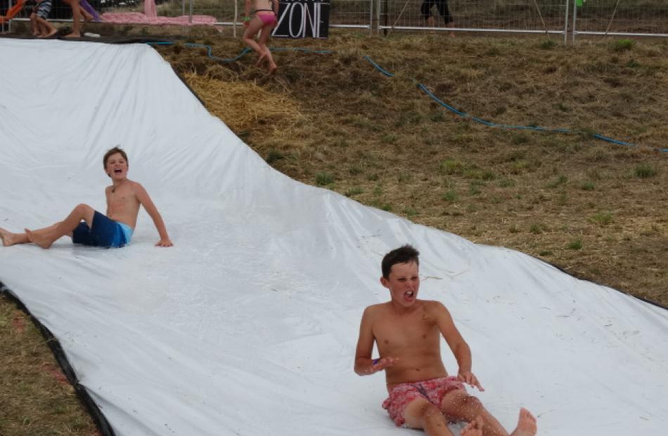 Ashton Redgewell (10, left) and Sage Kellahan (12) make the most of the water slide.