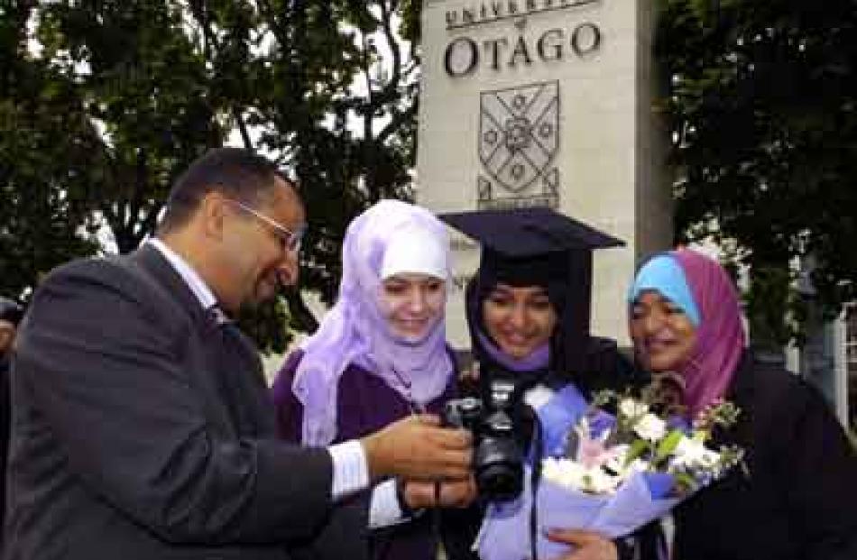 Muhammed Almaskari of Oman shows a picture to Assil Russell of Iraq, sister Alsha Almaskari (23)...