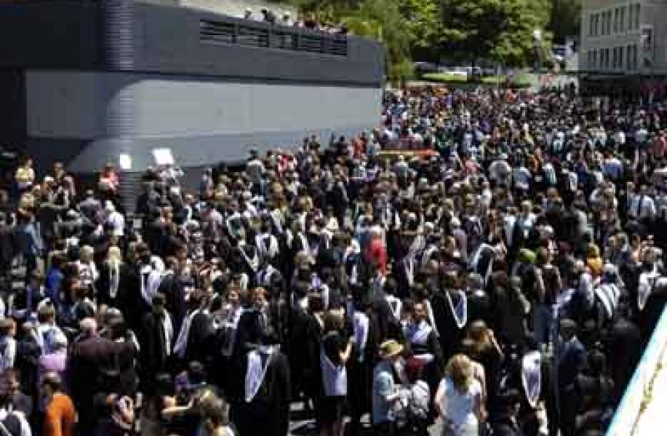 Graduands file in to the Dunedin Public Library carpark to be marshalled in correct capping order.