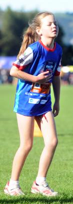 Emily Ferguson (9), of Dunedin, battles stitch as she tries to complete the 1.5km run yesterday.