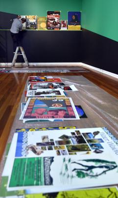 Former Wellington Media Collective member Chris McBride  hangs some of the posters created by the...