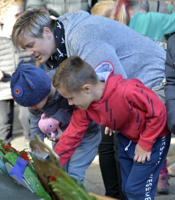 Melissa Hannagan helps sons Max and Isaac lay poppies after yesterday morning's Anzac service in...