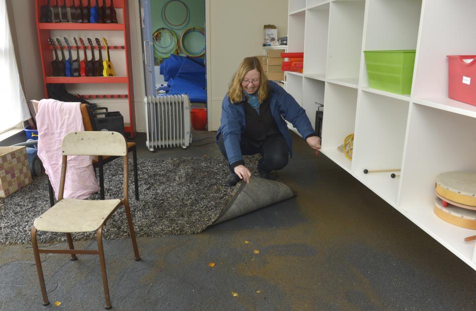 Macandrew Bay School principal Bernadette Newlands examines flood damage to the school's music room
