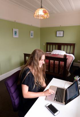 Frances Bridgman studies in her bedroom. The bed was made from floorboards lifted during the...