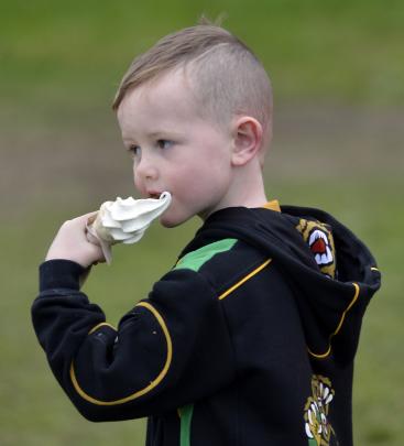 Young spectator Jesse Pellowe (5) enjoys an  ice cream.  