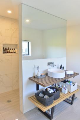 A round basin sits on spa-style slatted shelves in the en suite. 

