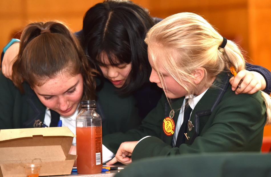 Columba College pupils Caitlin O'Brien (14, left), Angela Fu (14) and Emily Prout (14) push their...