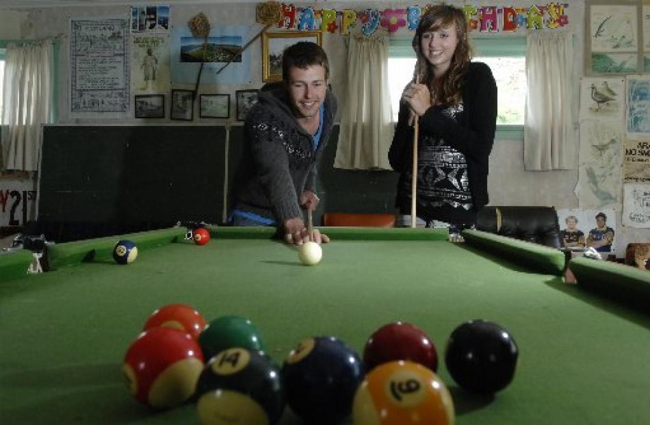 Cousins Louis (23) and Paige (15) Munro, of Dunedin, play pool at the family crib at Aramoana.