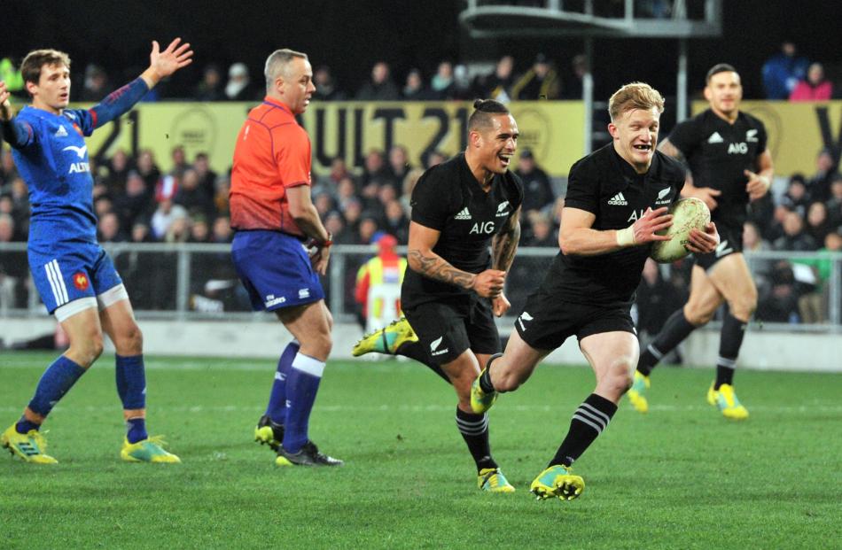 Damian McKenzie scores with the support of halfback Aaron Smith while French halfback Baptiste...