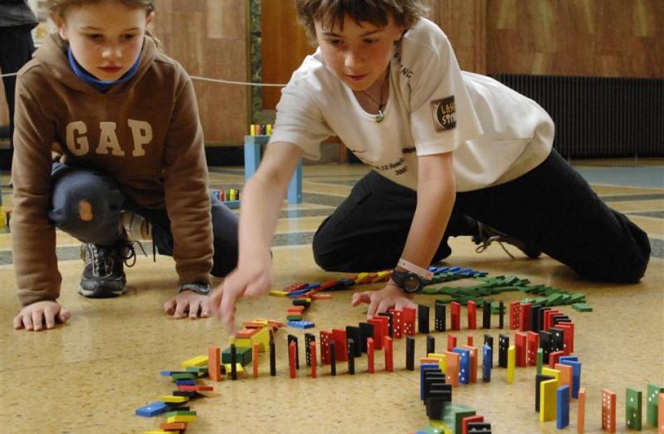 Ben Carr (10) and his sister Tatyana (7), of Waitati, absorb themselves in the toppling of nearly...