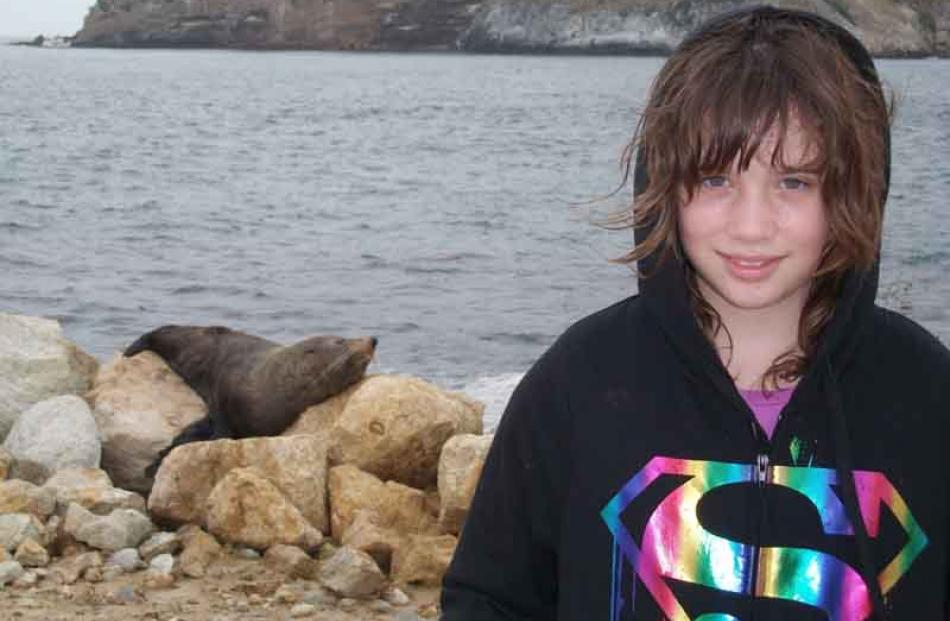 Claudia Gallagher (10) of Mosgiel with a New Zealand Fur Seal...Photo: Nickie Gallagher