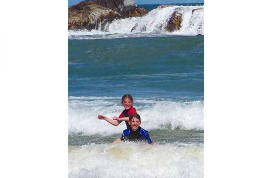 Brighton rocks . . . Georgia and Kate Heffernan (both 11), of Heriot, enjoy the surf at Brighton...