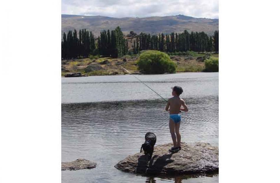 Take a dog fishing . . . Spencer Campbell (6) with his dog Harry at Butcher's Dam, Central Otago,...