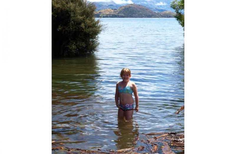 Cooling down . . . Maia Koen (7) on the flooded shore of Lake Wanaka on January 3. Photo:...