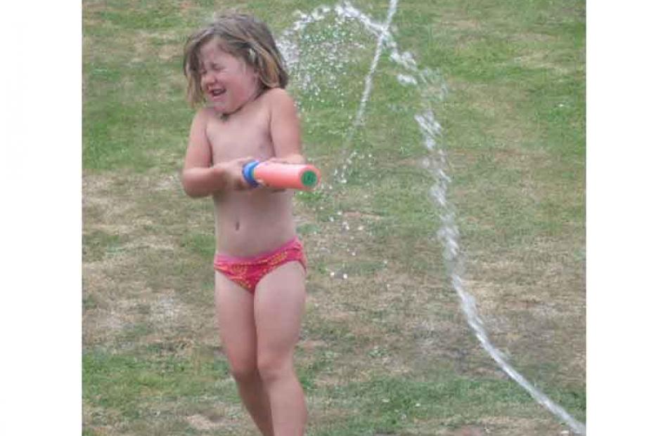 Pump action . . . Libby Gordon (5) in a water fight with her brother on Christmas Day. Photo:...