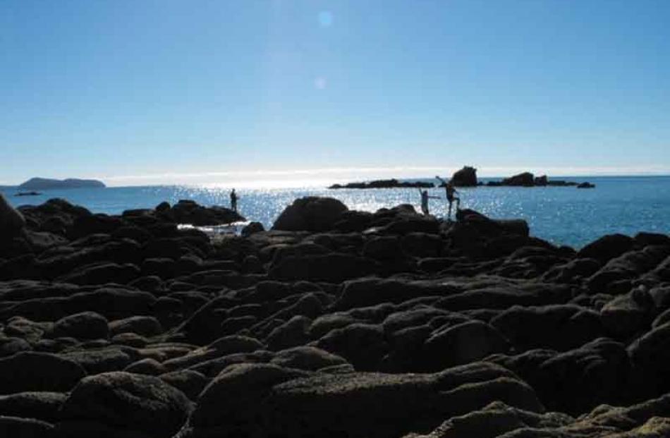 Morning cast . . . Nigel, Josh and Tash Whyte fish off rocks at Kaiteriteri beach, Nelson region....