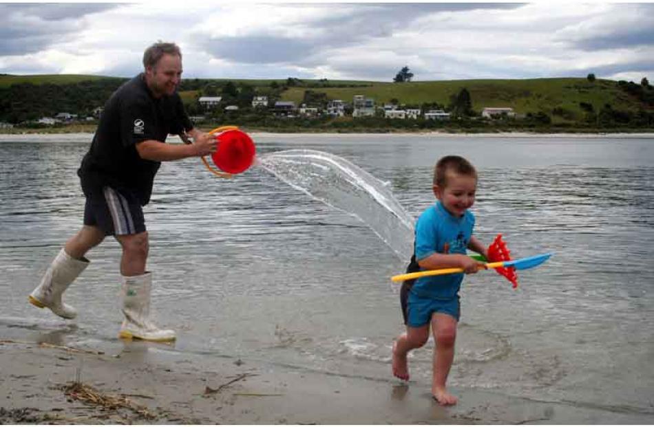 Catch me if you can! ... Mark Hurring and Matthew Hurring (3) play in the water at Taieri Mouth...