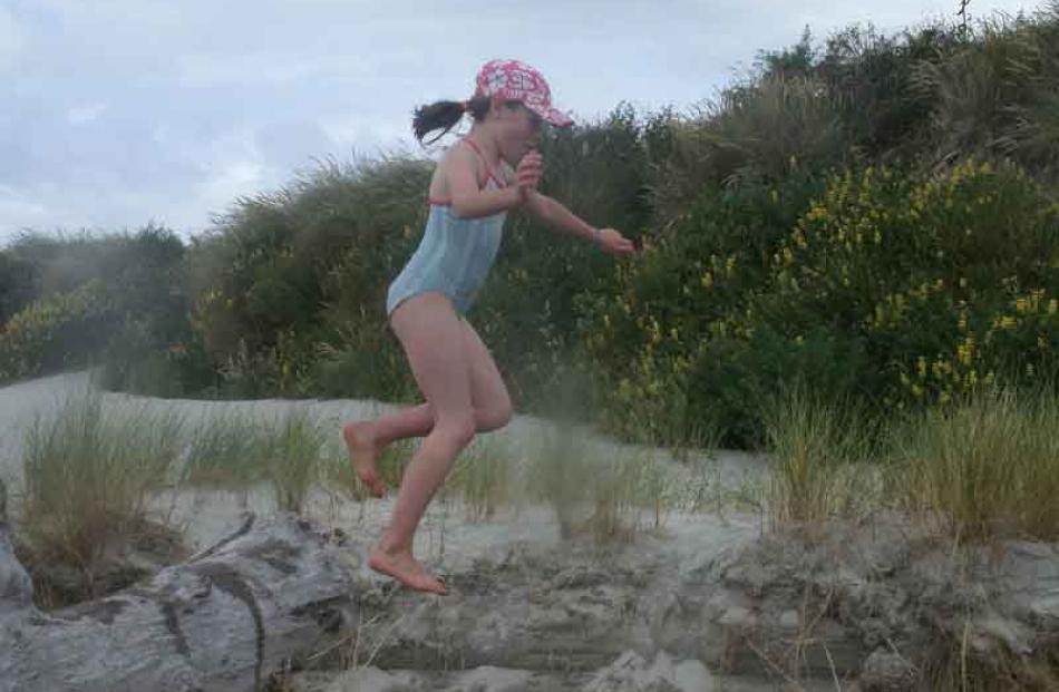 Easy as falling off a log . . . Alice Merriman (9) jumps into the creek at Measley beach, South...