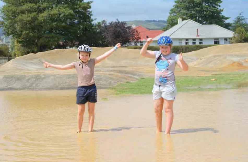 Thumbs up . . . Georgina Couper (11) and Samantha Couper (9) scout the new water feature at the...
