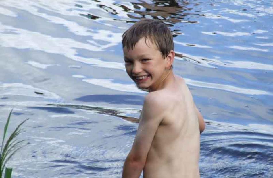 It's not that cold really . . . Logan Bird (9) of Owaka tests the water of the Owaka River on New...
