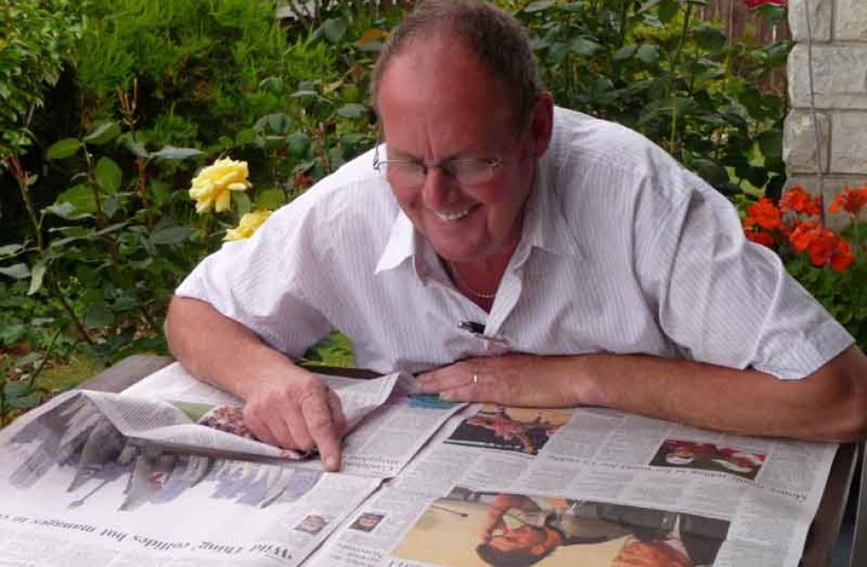 Sport section . . . Geoff Davis, of Palmerston, has his early morning study of the 'Otago Daily...