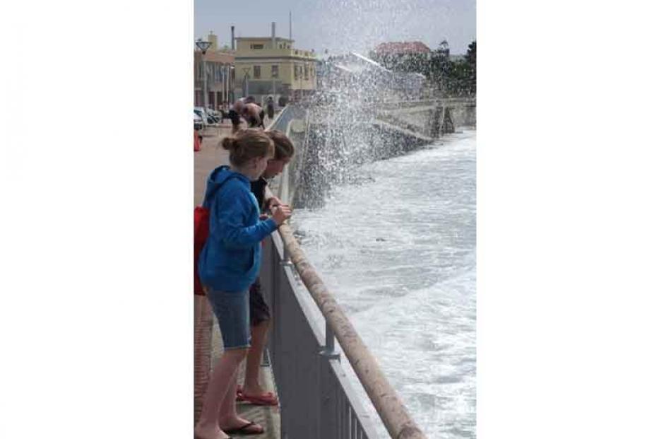 Catching a wave . . . Hannah White (11) and Sian Remon (10) cop a faceful while on their way to...
